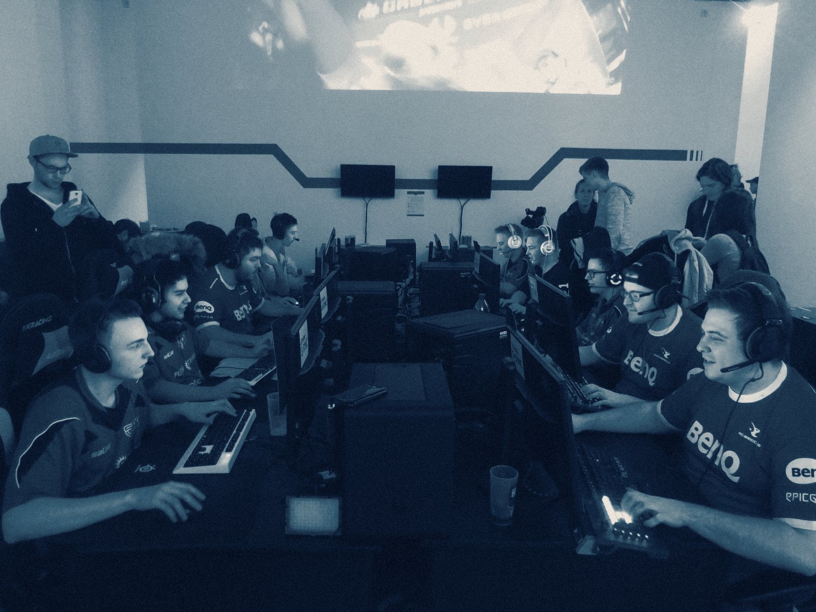 Rows of esports players at their stations with headsets on, mid-match at a LAN tournament